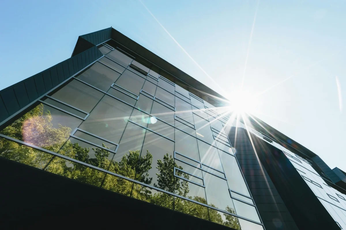 Moderne Besprechungsraum mit großen Fenstern, stilvollen Möbeln und natürlichem Licht, ideal für professionelle Meetings und Zusammenarbeit in einem Geschäftszentrum.